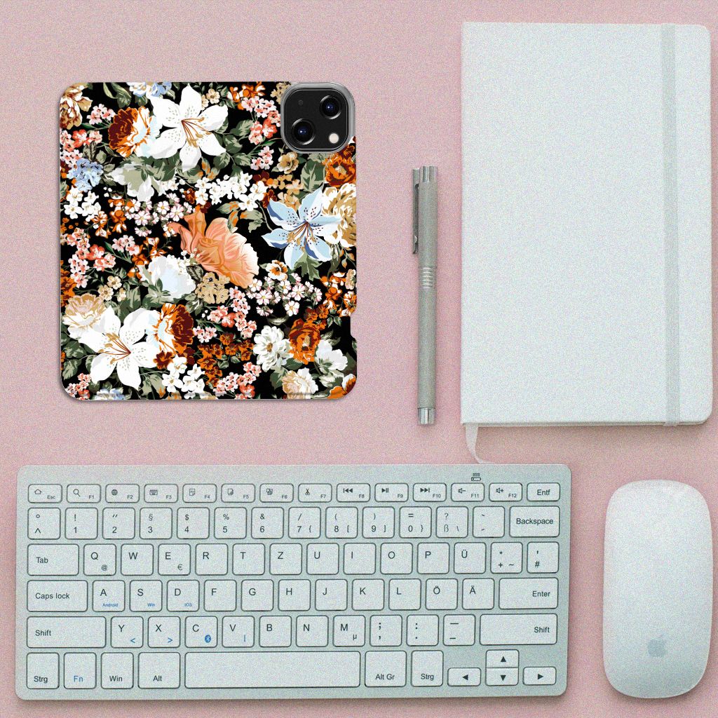 Smart Cover voor iPhone 14 Dark Flowers met kleurrijke bloemenprint op een bureau met een toetsenbord en notitieboek.