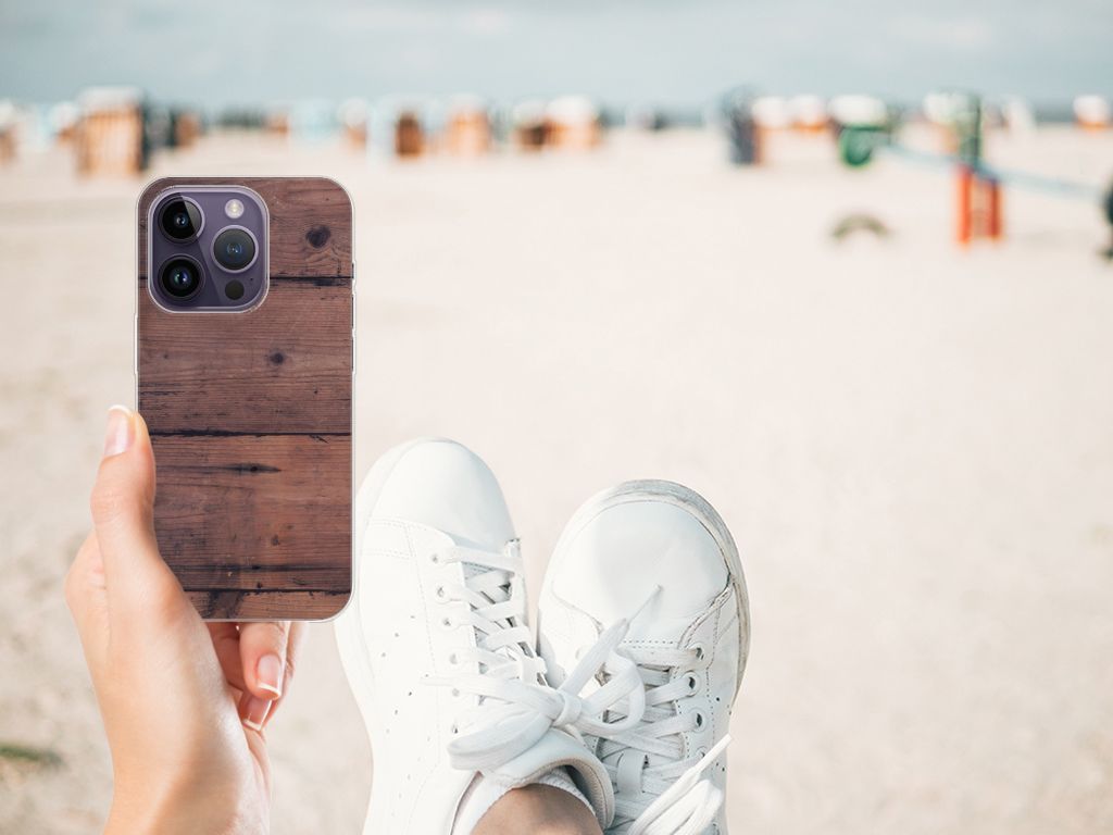 Apple iPhone 14 Pro Bumper Hoesje Old Wood met een hand op het strand en sneakers in de ontspanning.