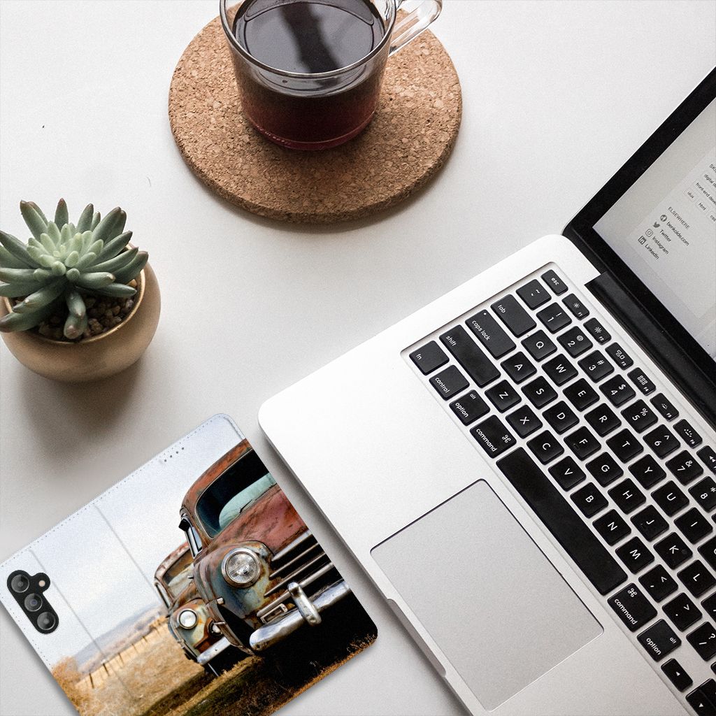 Samsung Galaxy A14 5G Stand Case Vintage Auto on a desk beside a laptop and a plant.