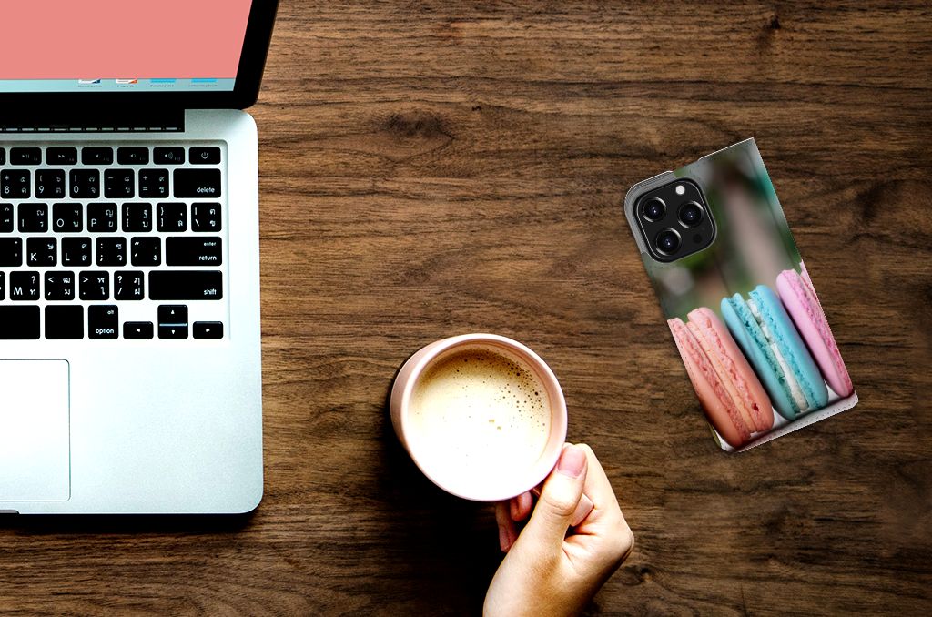 iPhone 13 Pro Flip Style Cover Macarons met pastelkleurige macarons op een bureau naast een kopje koffie ☕.