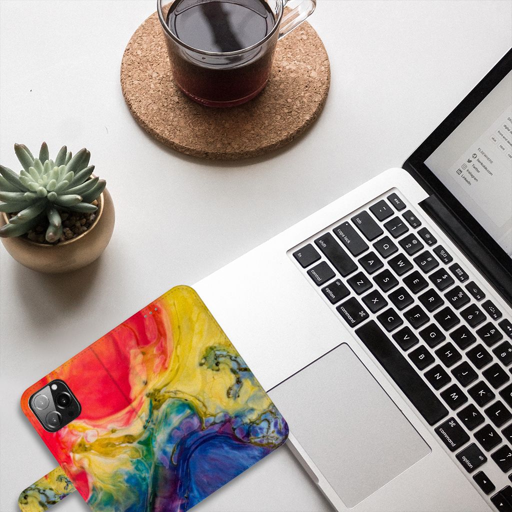 Hoesje iPhone 13 Pro Max Watercolor Dark met kleurrijk design op bureau met laptop en plantaardig decor.