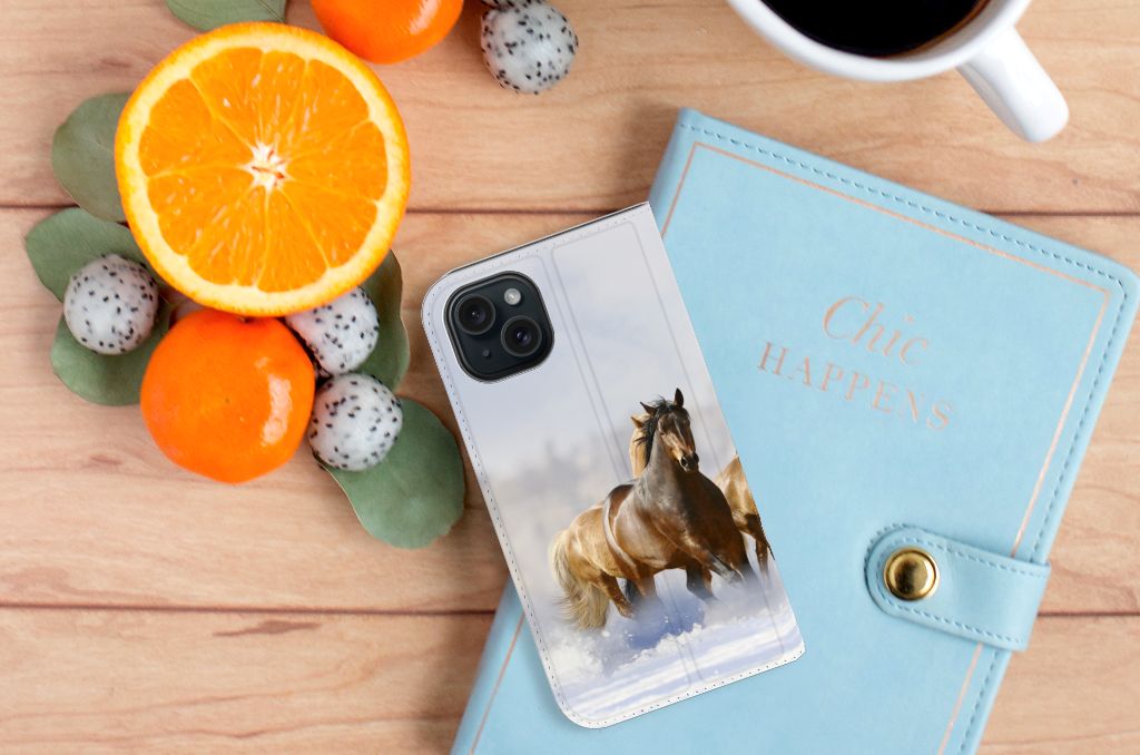 iPhone 15 Hoesje maken Paarden met paardensilhouetten op een houten tafel met citroen en notitieboek.