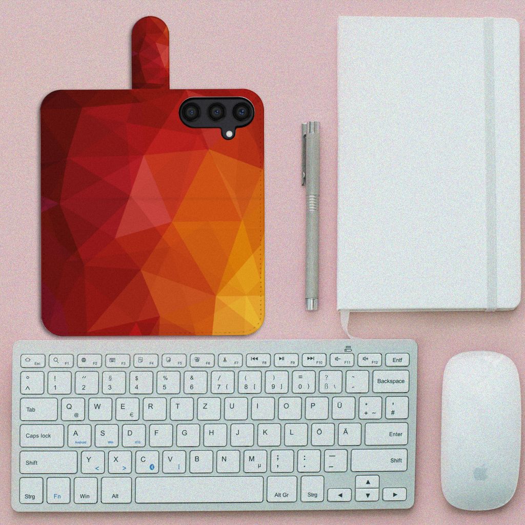 Book Case voor Samsung Galaxy S24 Polygon Red met abstracte vormen op een bureau met toetsenbord en notitieboek.
