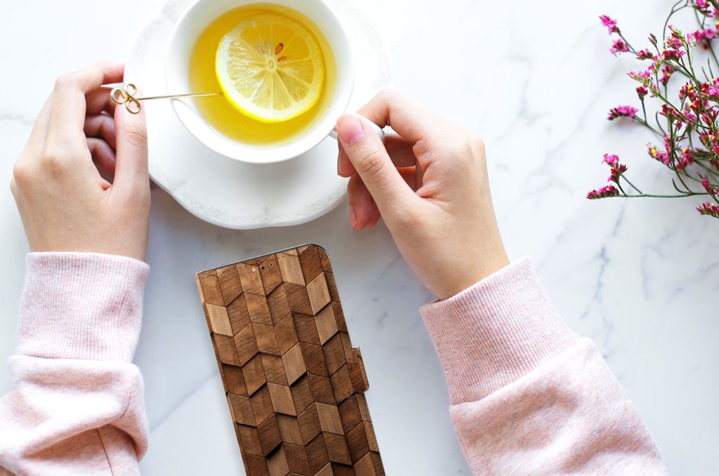 Comfortable hands holding a cup of tea next to Book Style Case voor Samsung Galaxy A03 Wooden Cubes, perfect cadeau. 🍋