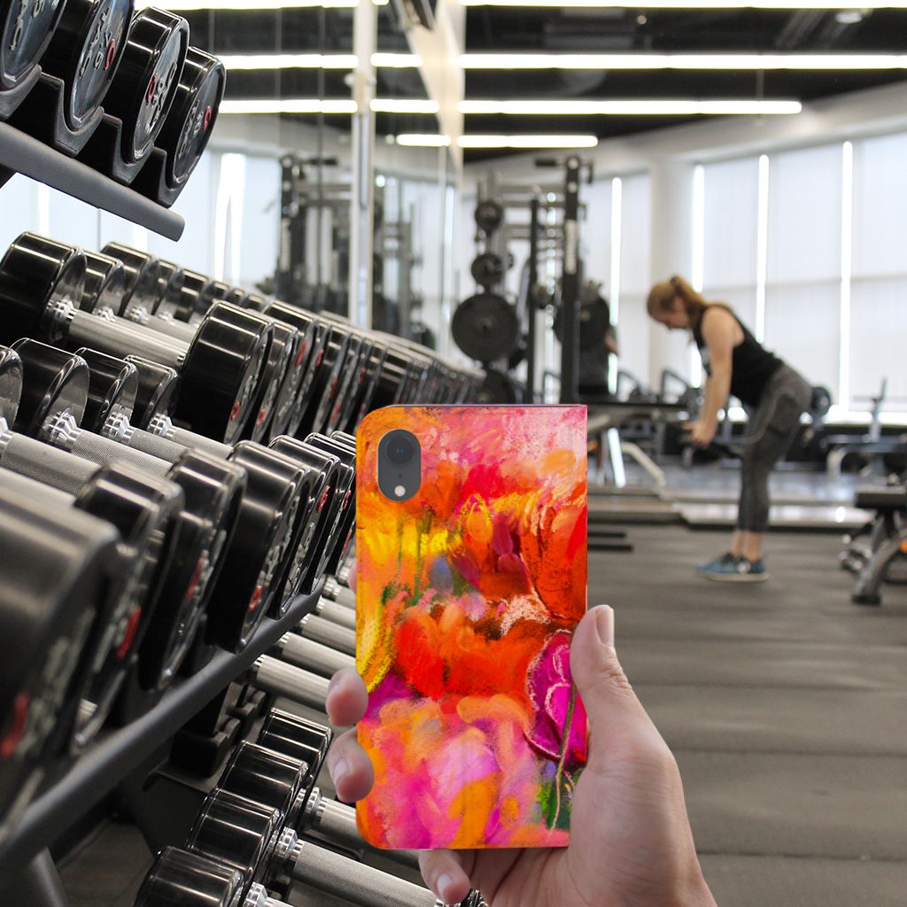 Bookcase Apple iPhone Xr Tulips design in a gym setting with weights and a person training.