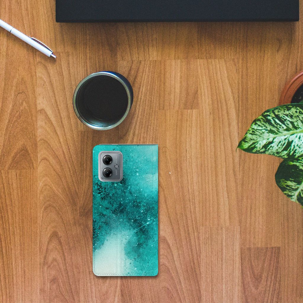 Bookcase Motorola Moto G14 Painting Blue op houten tafel met planten en een kopje koffie ☕