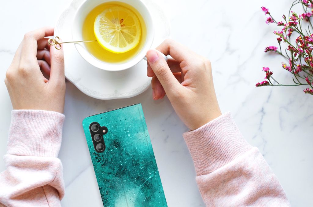 Bookcase Samsung Galaxy A14 4G Painting Blue with hands holding a tea cup and a plate on a marble table.