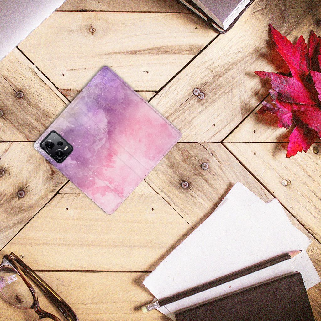 Bookcase Xiaomi Redmi Note 12 Pro | Poco X5 Pro Pink Purple Paint op een houten tafel met andere kantooraccessoires.