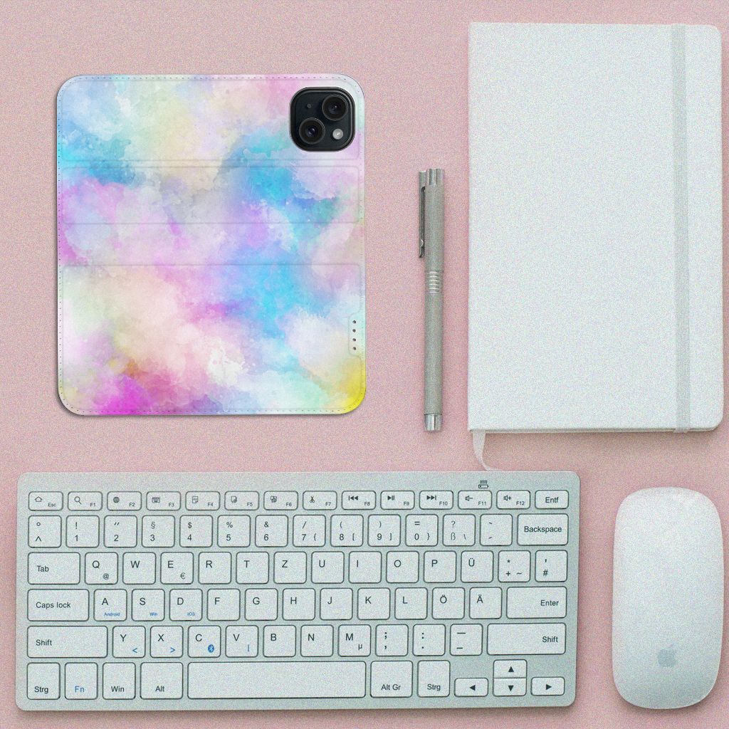 Bookcase iPhone 15 Watercolor Light design met kleurrijk, abstract patroon op een bureau met toetsenbord en notitieboek.