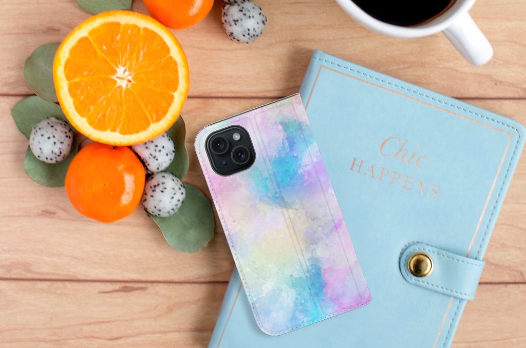 Bookcase iPhone 15 Watercolor Light design met kleurrijke watercolor achtergronden en fruit 🍊 op een houten tafel.