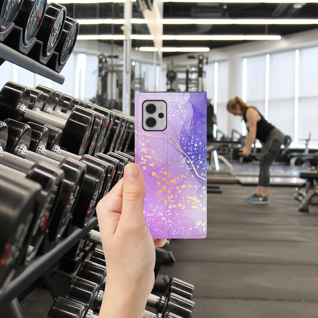 Bookcase voor Motorola Moto G13 | G23 Watercolor Paars in de sportschool met halters op de achtergrond.
