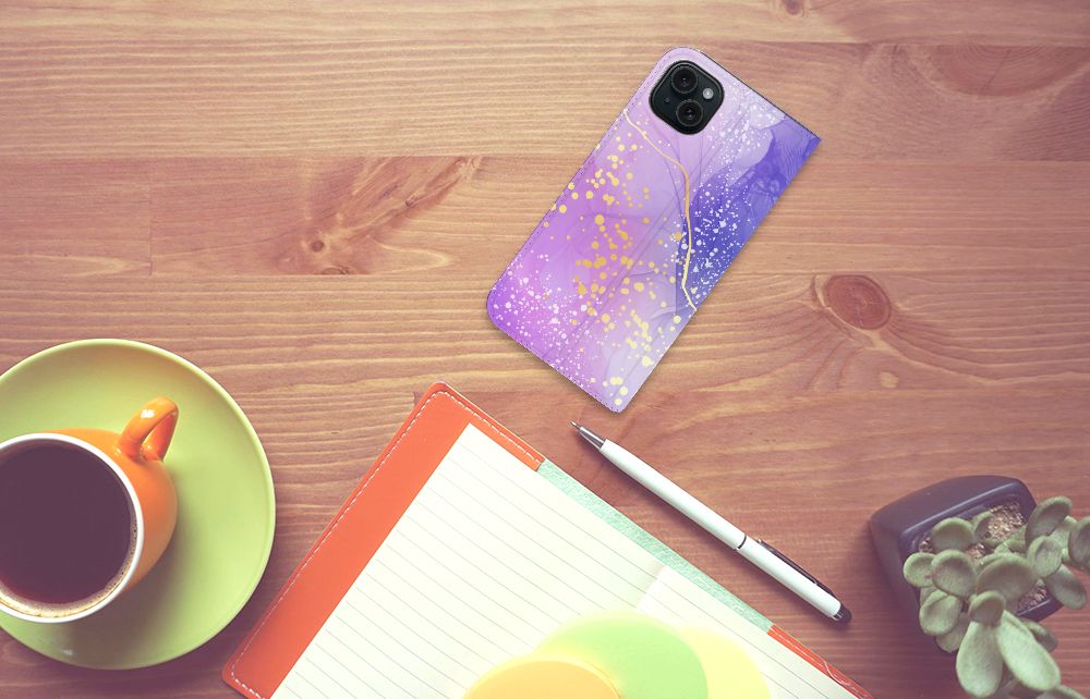 Bookcase voor iPhone 15 Plus Watercolor Paars op een houten tafel met notitieboek en kopje koffie ☕.