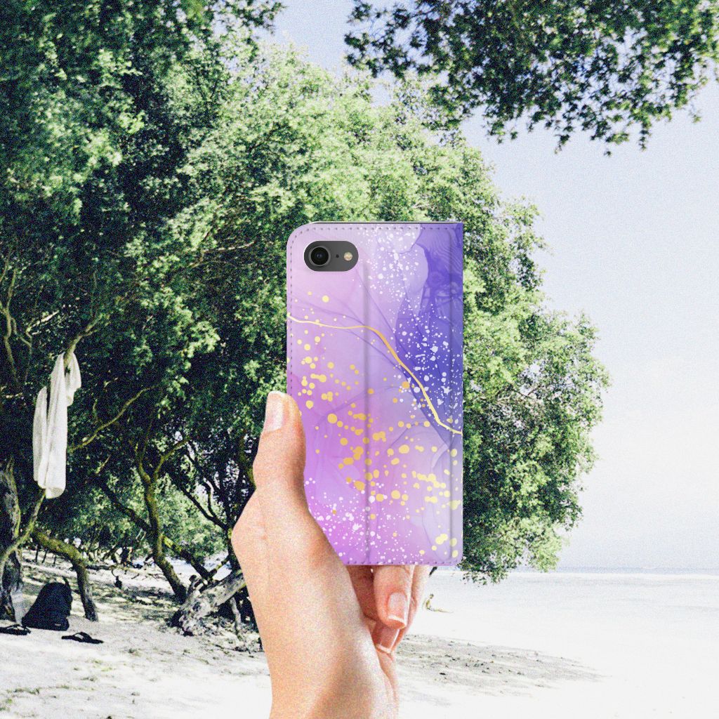 Bookcase voor iPhone 7 | 8 | SE (2020) | SE (2022) Watercolor Paars in een hand, met een prachtig paarse watercolor achtergrond.