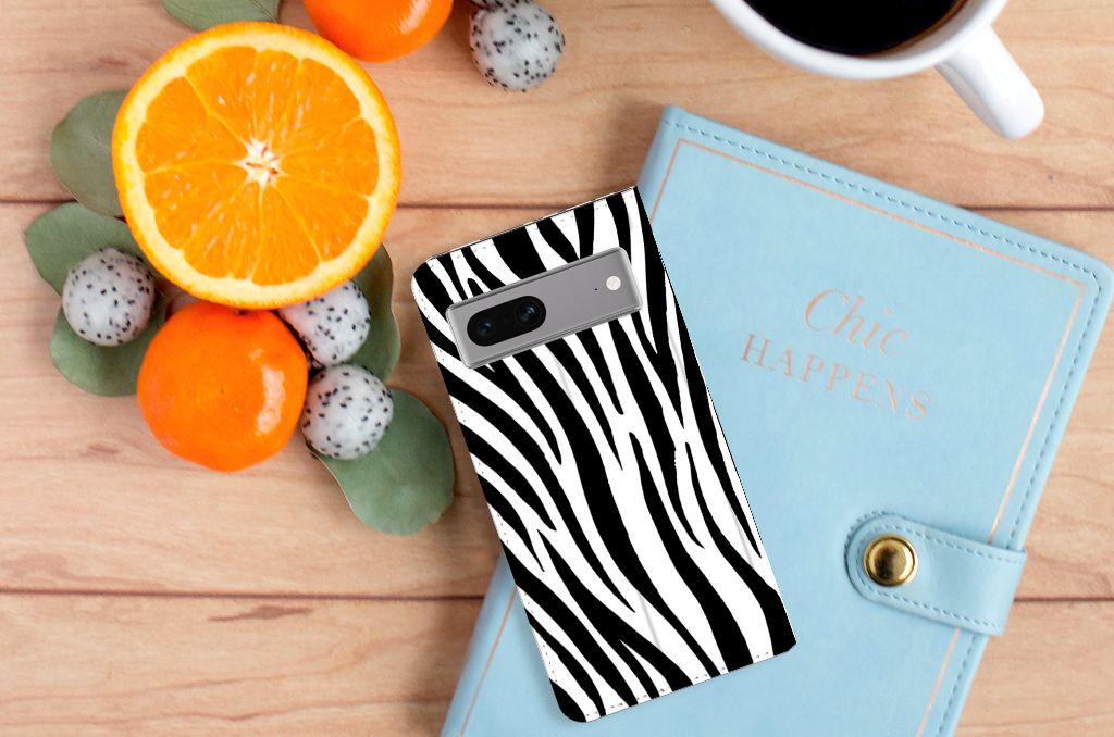 Google Pixel 7 Hoesje maken Zebra met zwart-witte strepen op een houten tafel met fruit en een notitieboekje.
