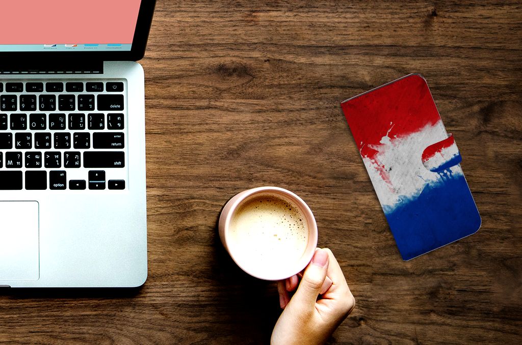 Google Pixel 7A Bookstyle Case Nederland naast laptop en koffie op houten tafel.