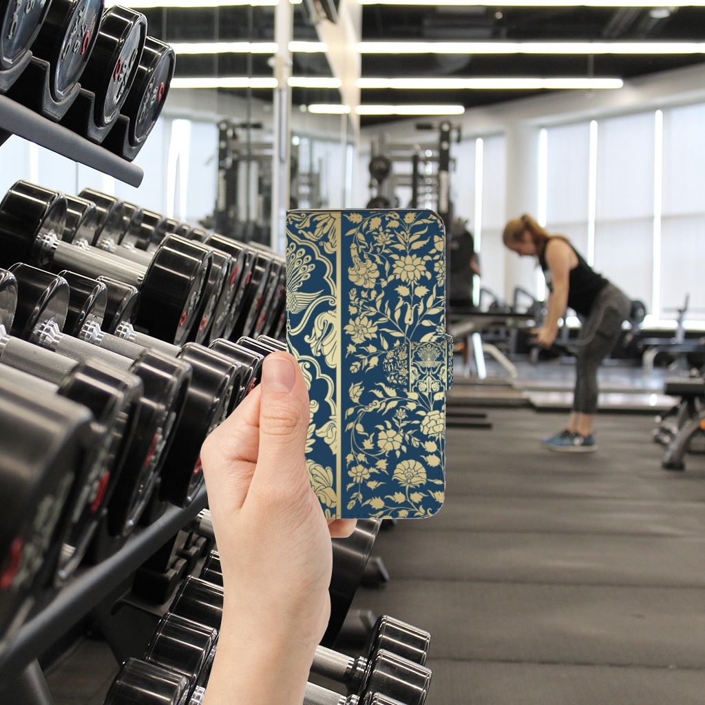 Google Pixel 7A Hoesje Beige Flowers met luxe design in fitnessomgeving en gewichten op de achtergrond.