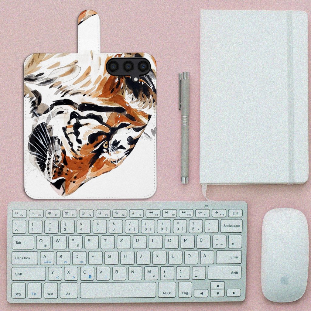 Hoesje Samsung Galaxy S24 Watercolor Tiger met abstract tijgerontwerp op een bureau met toetsenbord en notitieboek.