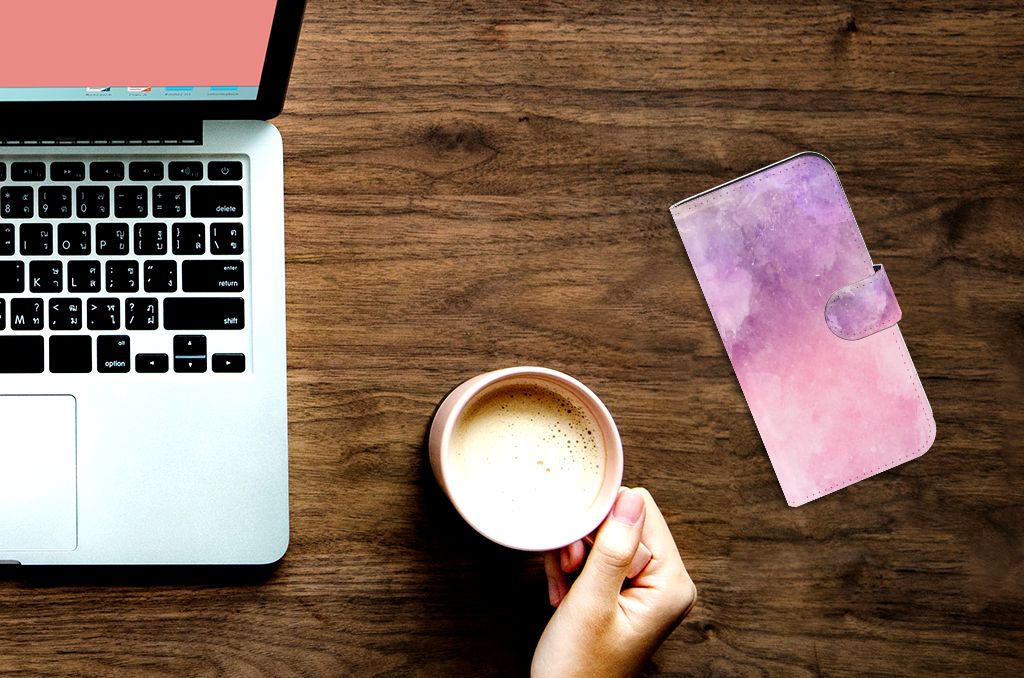 Hoesje iPhone 15 Pro Pink Purple Paint naast een laptop en een mok koffie.