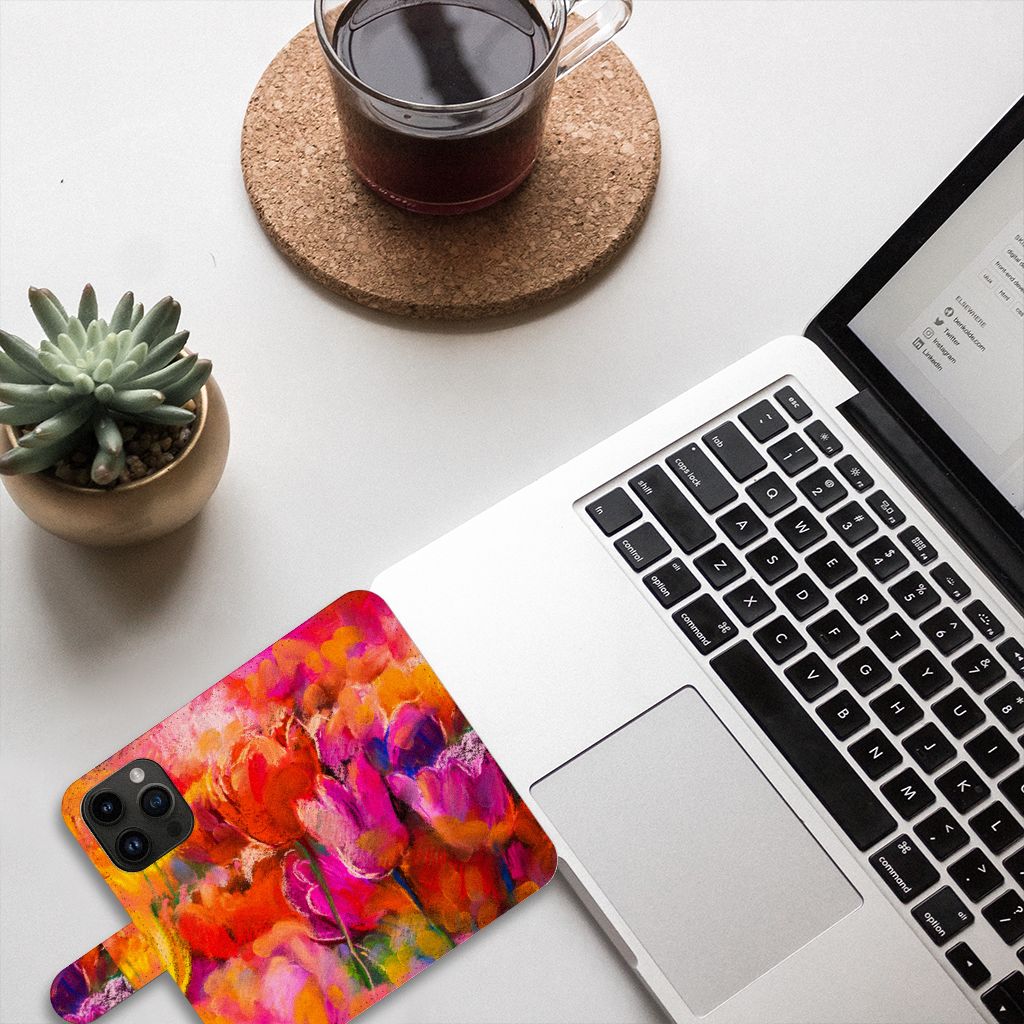 Hoesje iPhone 15 Pro Tulips met kleurrijk tulpen ontwerp naast laptop en plant 🌷.