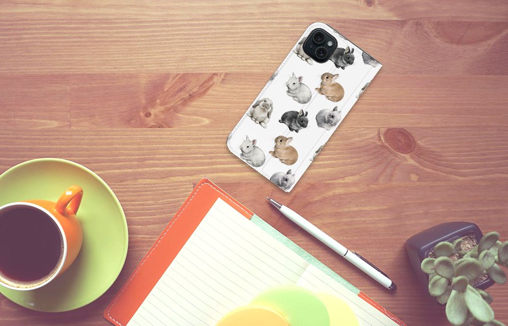 Hoesje maken voor iPhone 15 Plus Konijntjes met schattige konijnen op een bureau met een kopje koffie ☕.