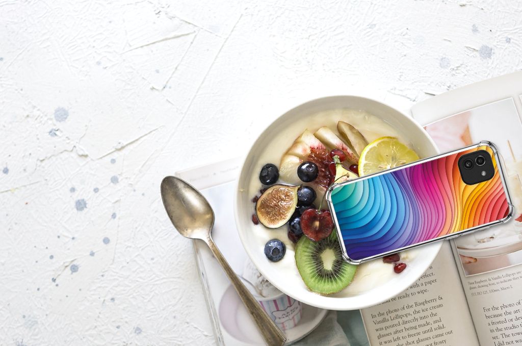 Hoesje maken voor iPhone 15 Pro Paard met kleurrijk design naast een kom fruit en een tijdschrift.