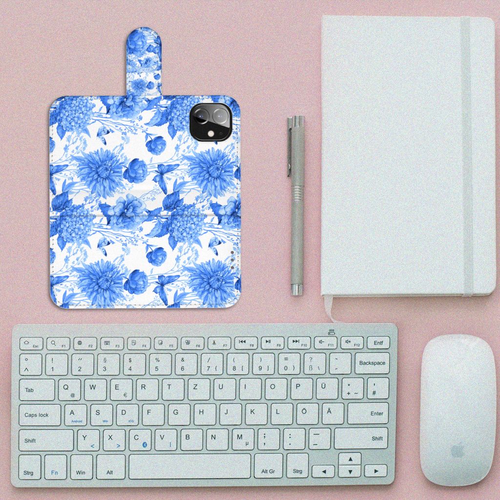 Hoesje voor Apple iPhone 12 Mini Flowers Blue met blauw bloemen design op een bureau met toetsenbord en notitieboek.
