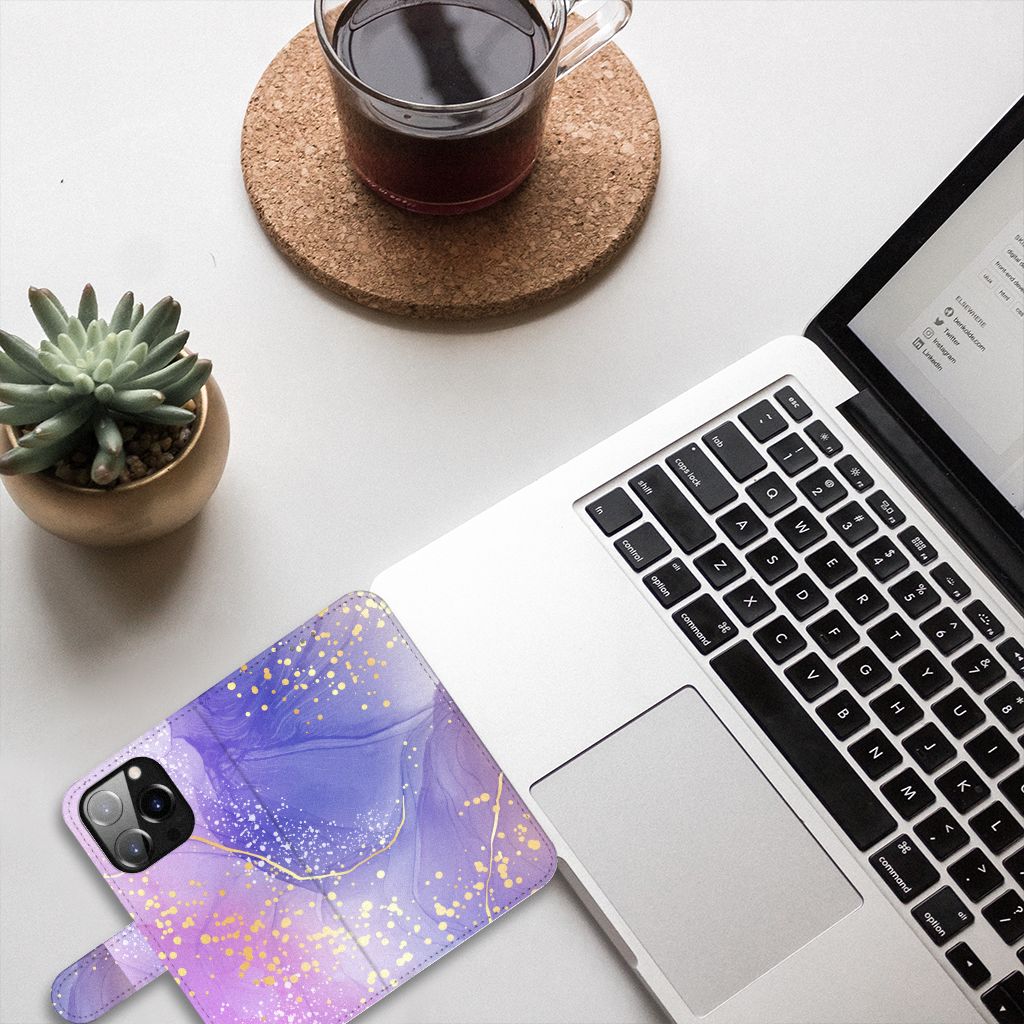 Hoesje voor iPhone 14 Pro Watercolor Paars op een bureau met laptop en plantje.