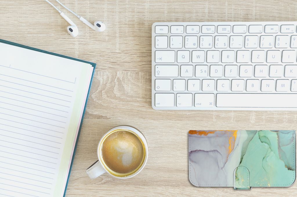 Hoesje voor iPhone 15 Plus Watercolor Mix op een bureau met koffie en notitieboek.