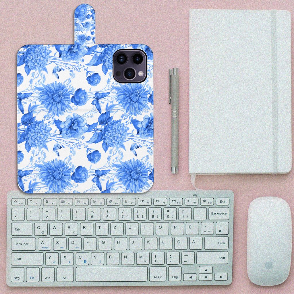 Hoesje voor iPhone 15 Pro Max Flowers Blue met blauw bloemenprint op een bureau met toetsenbord en notebook.
