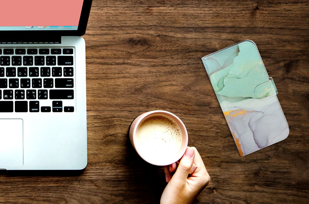 Hoesje voor iPhone 15 Pro Max Watercolor Mix naast een laptop en een kopje koffie.