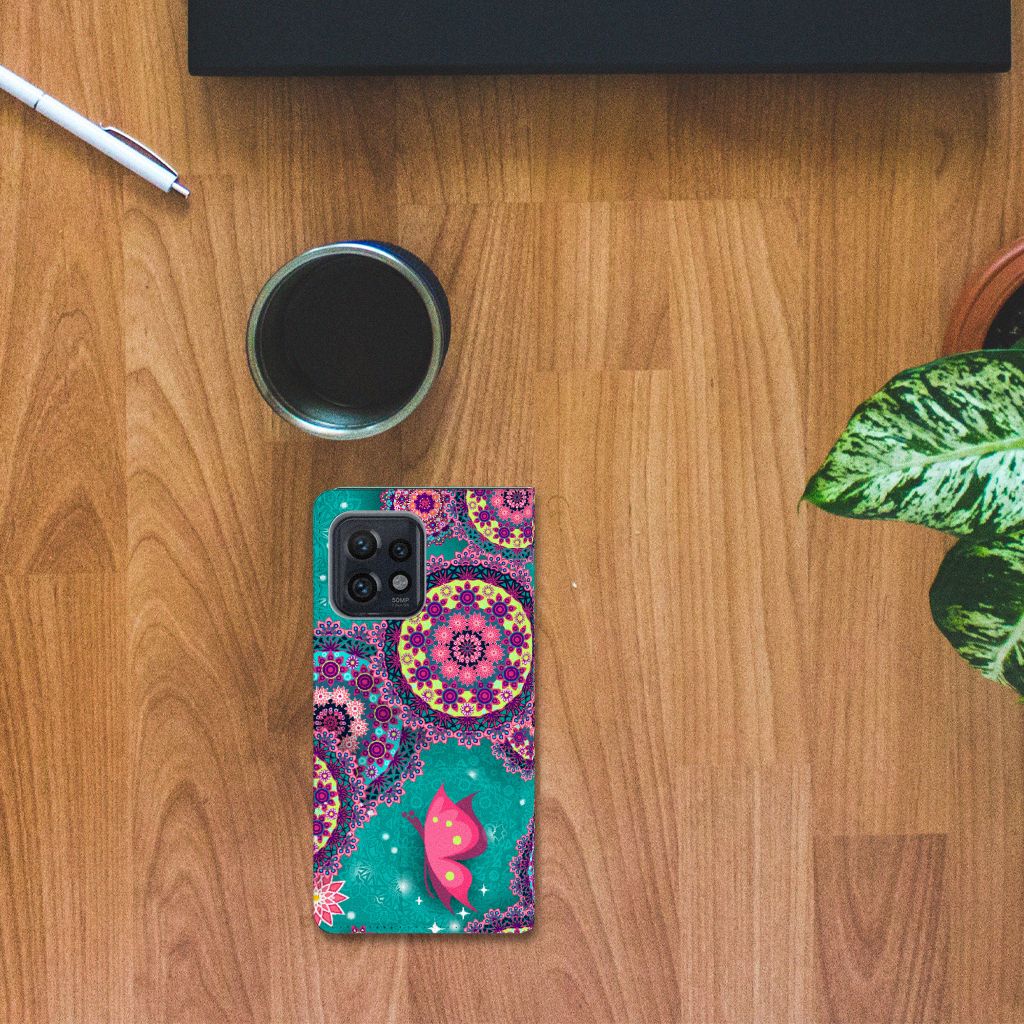 Motorola Edge 40 Pro Bookcase Cirkels en Vlinders op houten tafel met een plant en koffie.