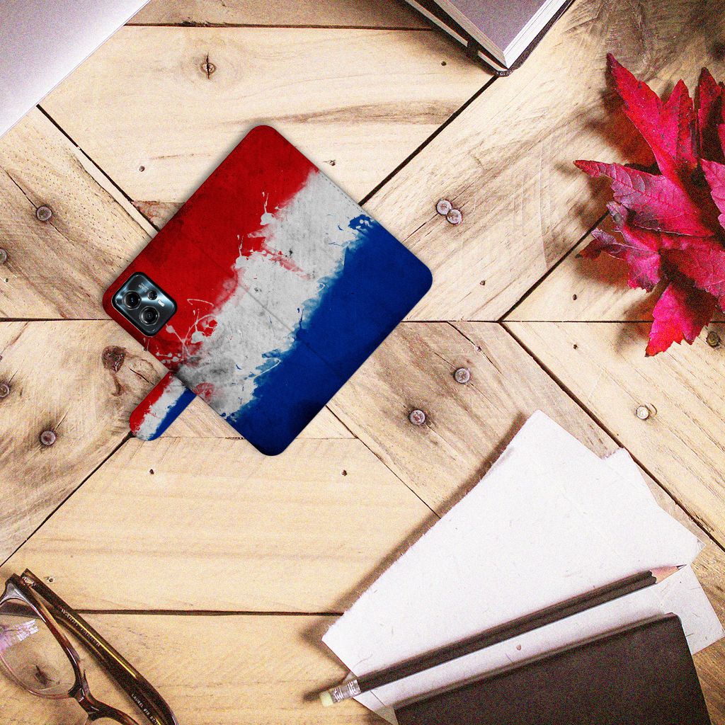 Motorola Moto G13 | G23 Bookstyle Case Nederland met artistieke Nederlandse vlag, gelegen op een houten tafel.