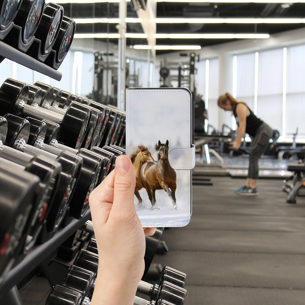Motorola Moto G14 Telefoonhoesje met Pasjes Paarden in hand tijdens fitness training voor gebruiksgemak en bescherming.