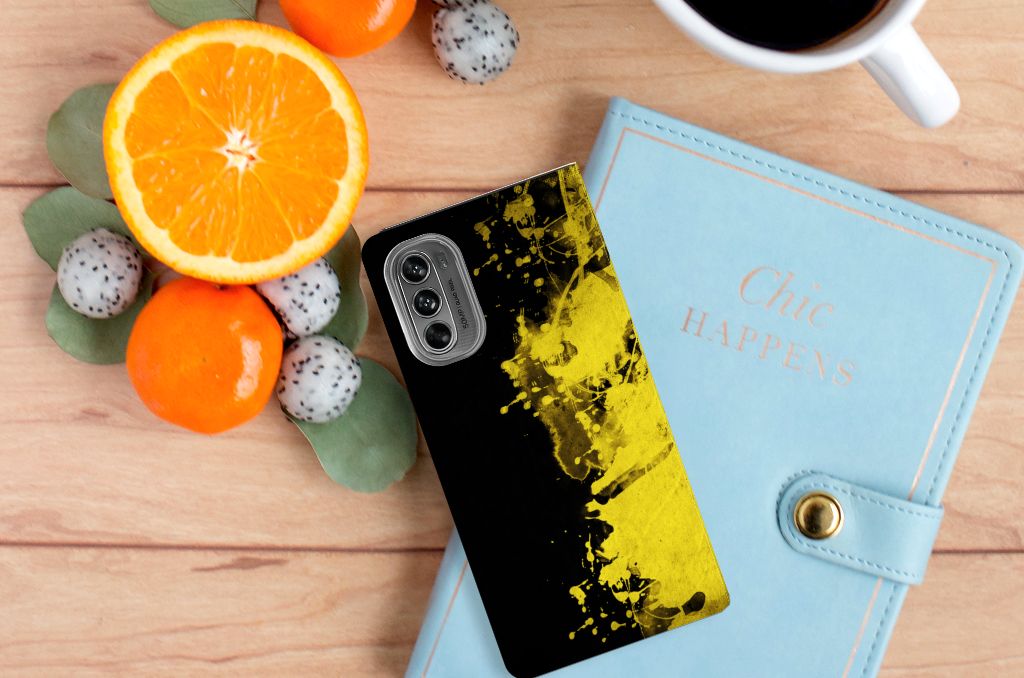 Motorola Moto G62 5G Standcase België met kleurrijk ontwerp op tafel met fruit en notitieboekje.