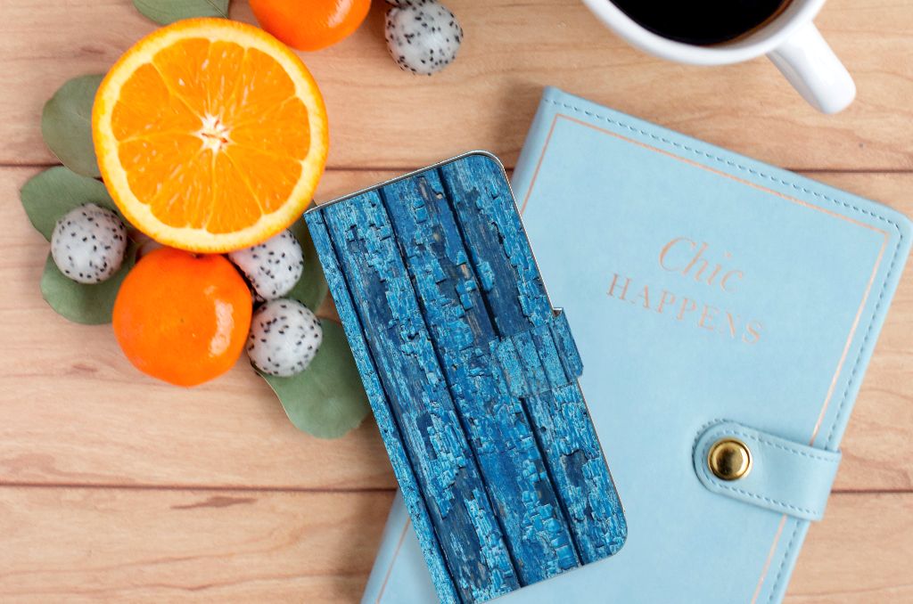 OPPO A58 4G Book Style Case Wood Blue met een kleurrijke achtergrond van fruit en een notitieboekje.