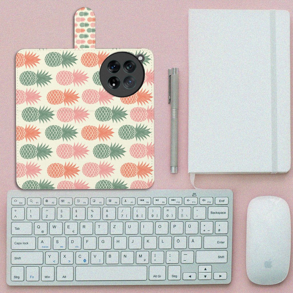 OnePlus 12 Book Cover Ananas met kleurrijke ananasdesign en toetsenbord op een bureau.
