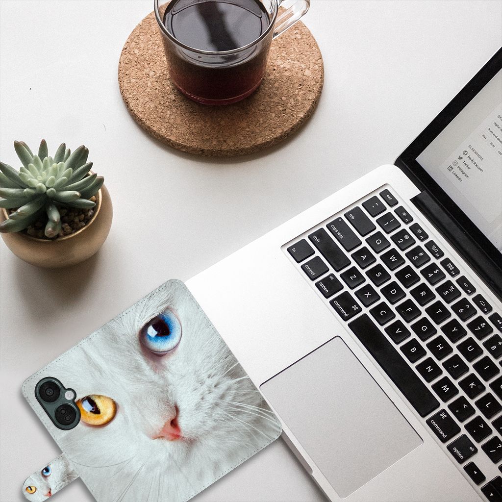 OnePlus Nord CE 3 Lite Telefoonhoesje met Pasjes Witte Kat met unieke ogen op bureautafel met laptop.