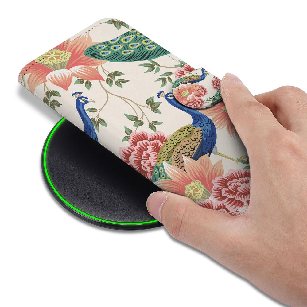 Samsung Galaxy S26 Plus Portemonnee Hoesje Pink Peacock handhouding met bloemenprint op draadloos opladen.