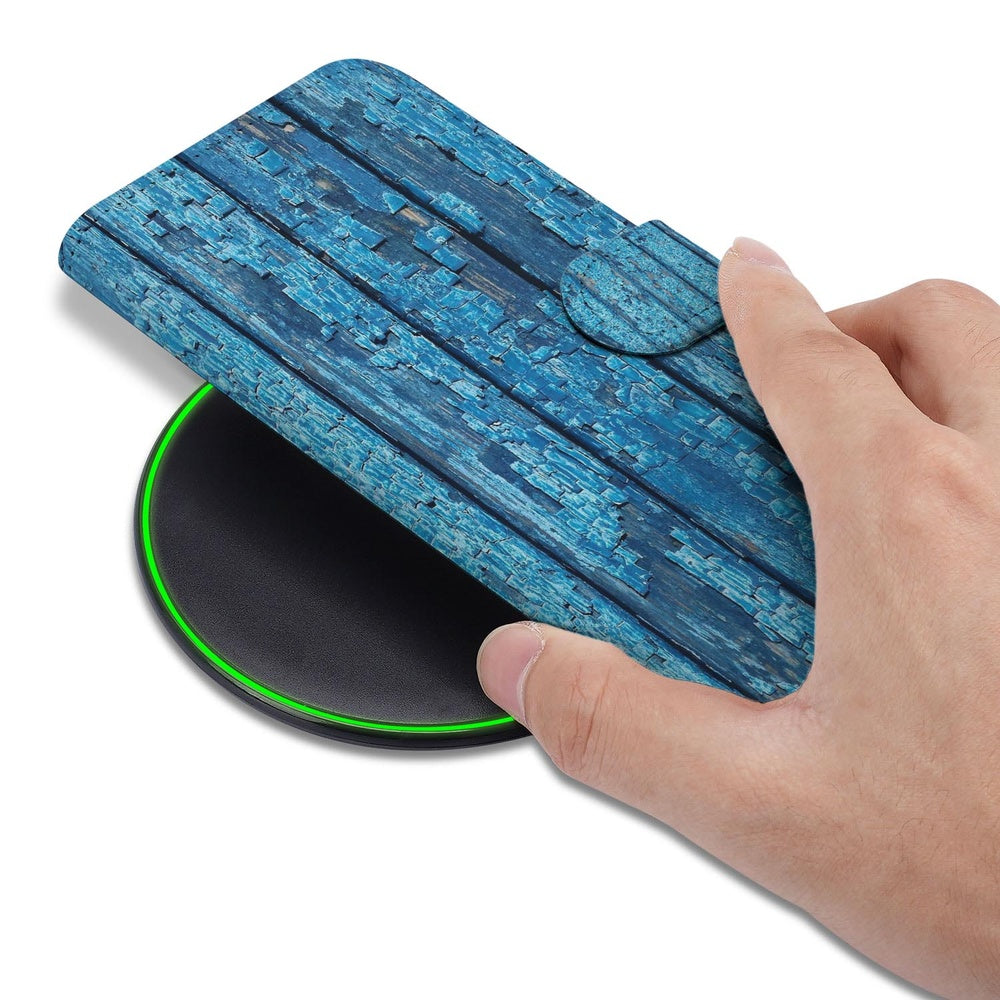Samsung Galaxy S26 Plus Book Case Afgebladderd Blauw Hout hand op draadloze oplader.
