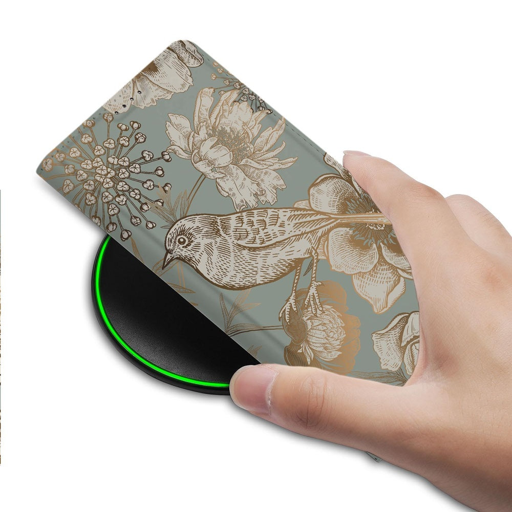 Samsung Galaxy S26 Plus Bookcase Vintage Bird Flowers detail met hand en draadloze oplader.