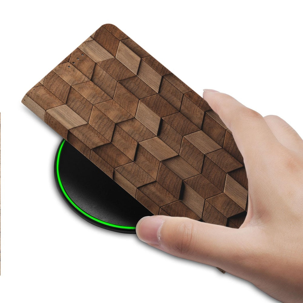 Samsung Galaxy S26 Plus Book Case Wooden Cubes hand die hoesje op draadloze oplader plaatst.