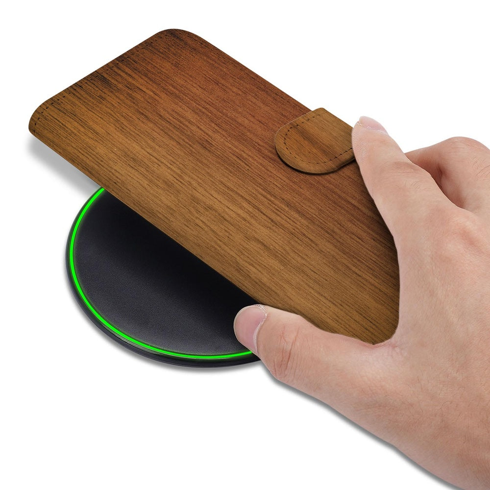 Samsung Galaxy S26 Bookcase Hoesje Donker Hout detail met hand en draadloze oplader.