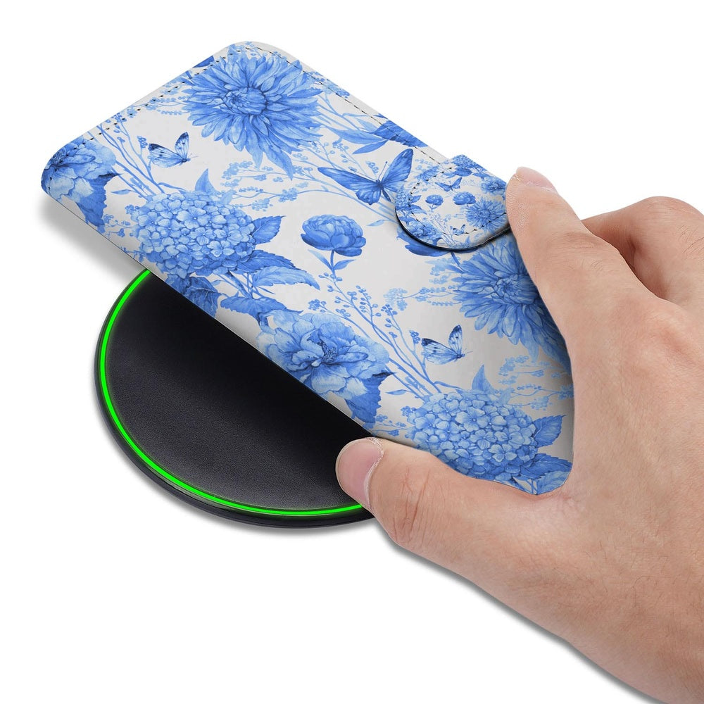 Samsung Galaxy S26 Book Case Blauw Bloemen detail hand op draadloze lader.