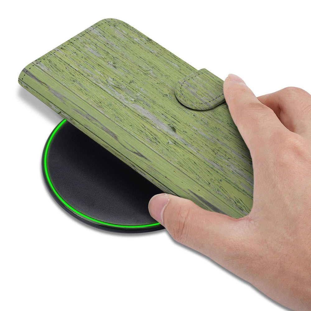 Bookcase Samsung Galaxy S26 Groen Houtnerf detail met hand op draadloze oplader.