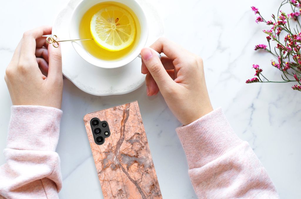 Samsung Galaxy A13 (4G) Standcase Marmer Oranje hand met telefoon en thee