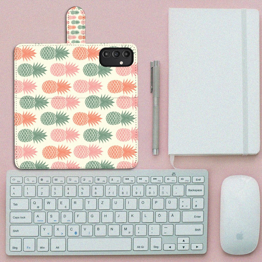 Samsung Galaxy A14 4G Book Cover Ananas op een bureau met toetsenbord en notitieboek.