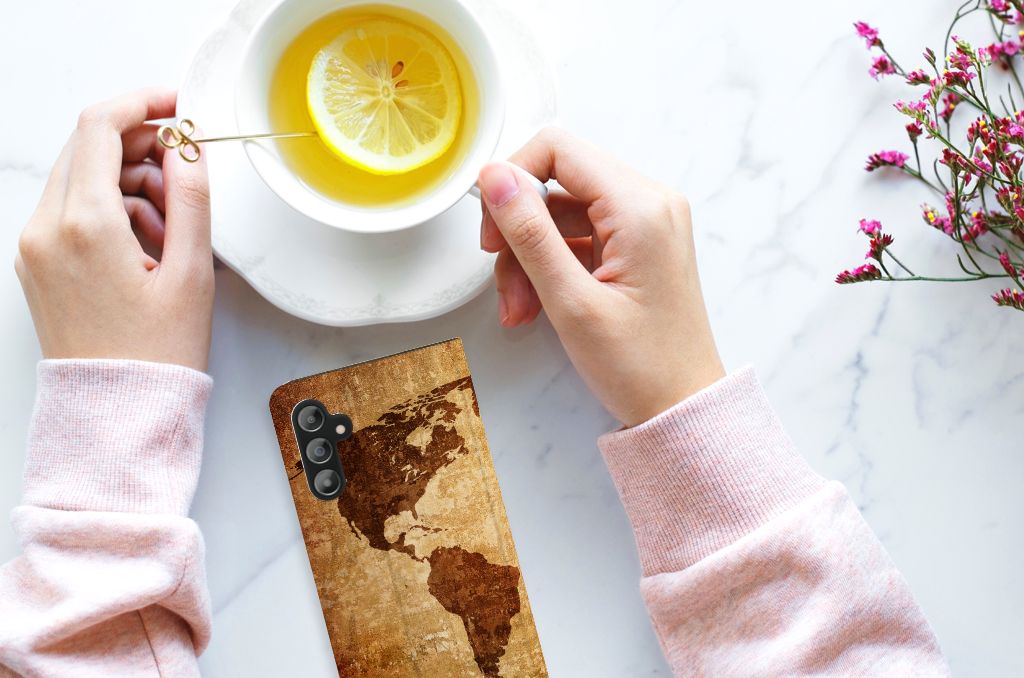 Samsung Galaxy A14 4G Book Cover Wereldkaart naast een kopje thee met citroen op tafel.
