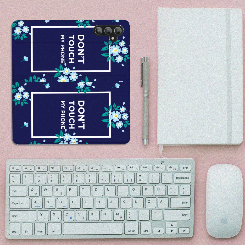 Samsung Galaxy A14 4G Design Case Flowers Blue DTMP on a desk with keyboard and notebook.