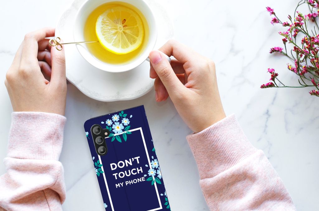 Samsung Galaxy A14 4G Design Case Flowers Blue DTMP displayed next to a cup of tea with lemon.