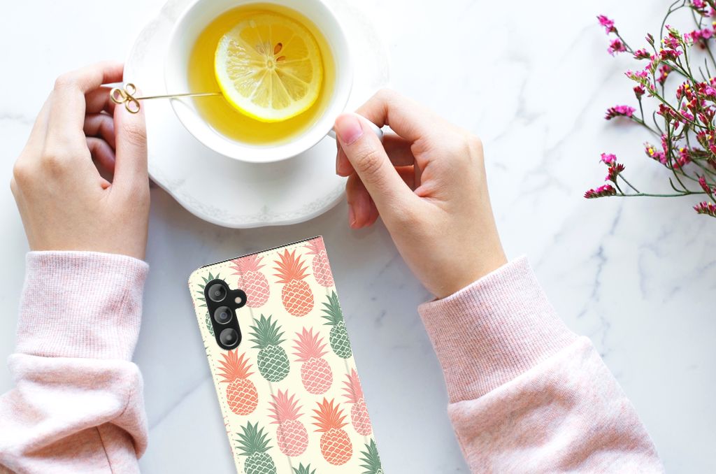 Samsung Galaxy A14 4G Flip Style Cover Ananas on a stylish table with a cup of tea and lemon.